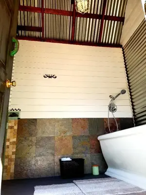 a bathroom with a wall with a sign on it at Sacred Mtn River Suites in Kernville