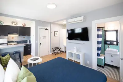 a living room with a bed and a kitchen and a room at Broadlind Hotel in Long Beach