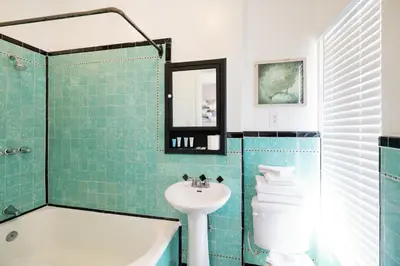 a bathroom with a sink and a tub and a toilet at Broadlind Hotel in Long Beach
