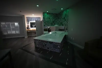 a bathroom with a sink and a green wall at Mid City Inn & Suites Pico Rivera in Pico Rivera