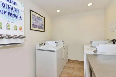 a laundry room with a washer and dryer at Best Western Plus Raffles Inn & Suites in Anaheim
