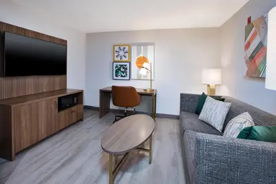 a living room with a couch and a flat screen tv at Holiday Inn Ontario Airport - California by IHG in Ontario