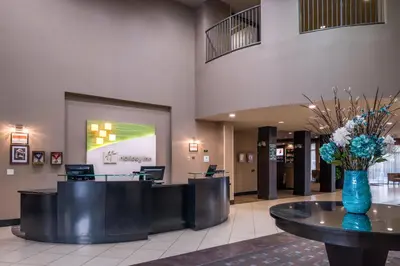 a lobby with a vase of flowers on a table at Holiday Inn Ontario Airport - California by IHG in Ontario