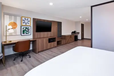 a hotel room with a bed and a desk with a television at Holiday Inn Ontario Airport - California by IHG in Ontario