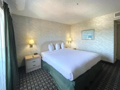 a bedroom with a large white bed with two pillows at Park Suites Hotel in South El Monte