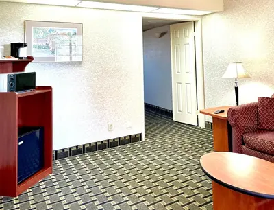 a living room with a couch and a table at Park Suites Hotel in South El Monte