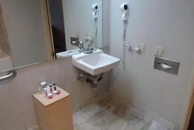 a bathroom with a sink and a mirror at Park Suites Hotel in South El Monte