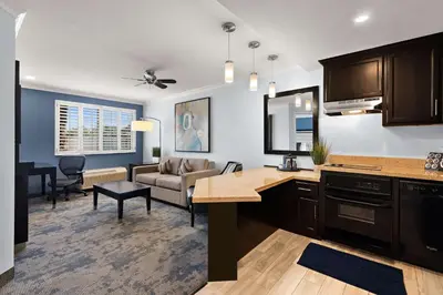 an open kitchen and living room with a couch at City Express by Marriott Manhattan Beach in Manhattan Beach