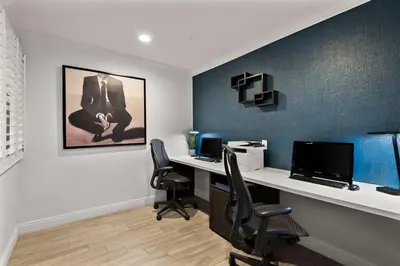 an office with a desk with a computer and two chairs at City Express by Marriott Manhattan Beach in Manhattan Beach