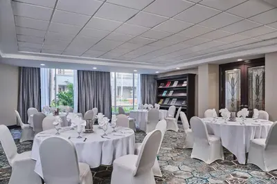 a room with white tables and white chairs and tablesearcher at DoubleTree by Hilton Chatsworth in Chatsworth