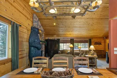 a dining room with a table and a bear on the wall at All About Fun-1149 by Big Bear Vacations in Big Bear Lake