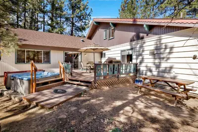 a house with a deck with a hot tub at Moose Creek Chalet-1237 by Big Bear Vacations in Big Bear Lake