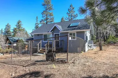 a house with a fence in front of a yard at Mountain Modern-1743 by Big Bear Vacations in Big Bear Lake
