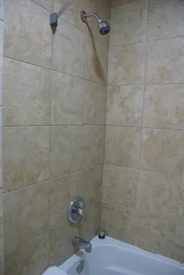 a shower with a shower head in a bathroom at Queens Inn Anaheim in Anaheim