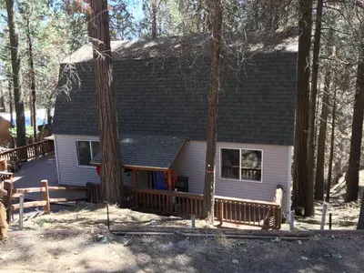 a small house with a deck in the woods at Sequoia National Forest CabinG in Panorama Heights