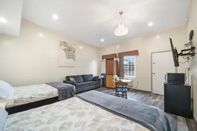 a bedroom with a bed and a couch and a television at 24 Hours Motel in Los Angeles