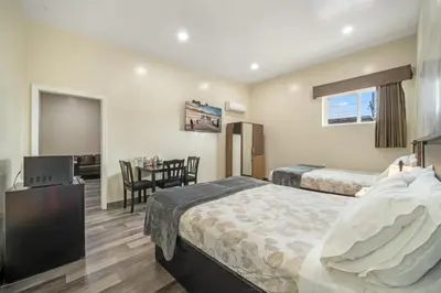 a hotel room with two beds and a table at 24 Hours Motel in Los Angeles