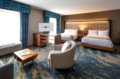 a hotel room with two beds and a desk and chairs at Bear Springs Hotel in Highland