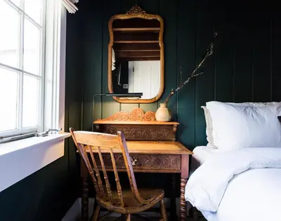 a bedroom with a desk with a mirror and a chair at The Venice Beach House in Los Angeles