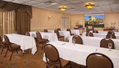 a banquet room with white tables and chairs at ALO Hotel by Ayres, Orange in Anaheim