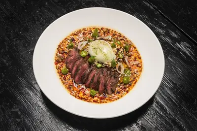 a plate of food with meat and vegetables on a table at ALO Hotel by Ayres, Orange in Anaheim