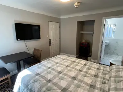 a bedroom with a bed and a desk and a television at Griffith Park Motel, in Los Angeles Hollywood Area in Glendale