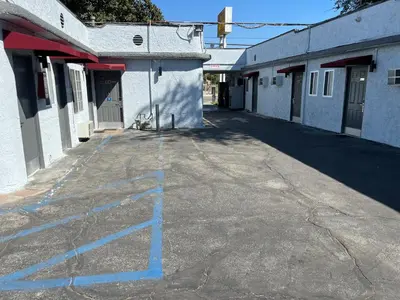 an empty parking lot with blue lines on a building at Griffith Park Motel, in Los Angeles Hollywood Area in Glendale