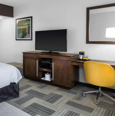 a hotel room with a desk with a television and a chair at Hampton Inn & Suites Los Angeles/Hollywood, CA in Los Angeles