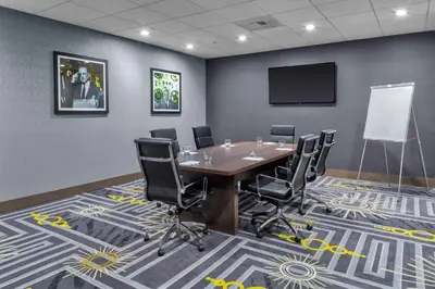 a conference room with a table and chairs and a screen at Hampton Inn & Suites Los Angeles/Hollywood, CA in Los Angeles