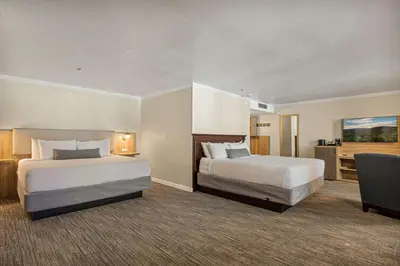 a hotel room with two beds and a desk at Chateau Big Bear Boutique Hotel, BW Signature Collection in Big Bear Lake