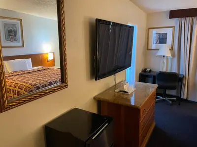 a hotel room with a bed and a large mirror at Grand Inn in Fullerton