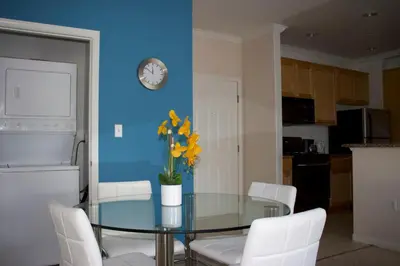 a dining room with a glass table with yellow flowers at Amazing Apartments near the grove in Los Angeles