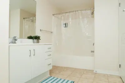 a white bathroom with a shower and a sink at Amazing Apartments near the grove in Los Angeles