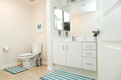 a bathroom with a toilet and a sink and a mirror at Amazing Apartments near the grove in Los Angeles