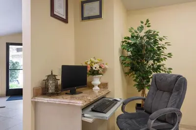 a room with a desk with a computer and a chair at Triplodge of Santa Clarita in Santa Clarita