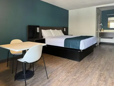 a hotel room with a bed and a table and chairs at Studio 6 Suites Gardena, CA in Gardena