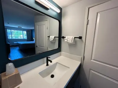 a bathroom with a sink and a large mirror at Studio 6 Suites Gardena, CA in Gardena