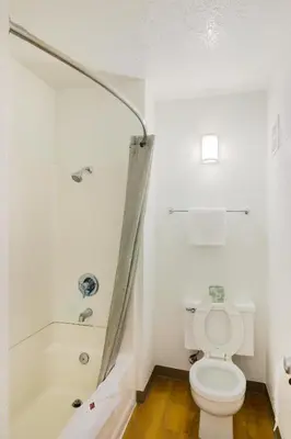 a white bathroom with a toilet and a bath tub at Motel 6-Camarillo, CA in Camarillo