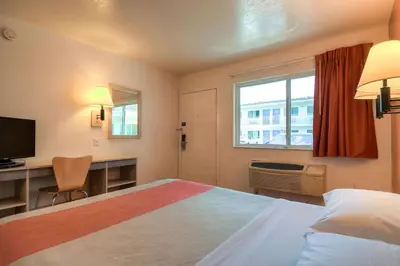a hotel room with a bed and a desk and a window at Motel 6-Westminster, CA - South - Long Beach Area in Westminster