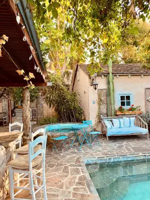 a patio with a table and chairs next to a pool at Under the Tuscan Sun Cottage in West Los Angeles in Los Angeles
