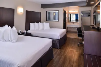 a hotel room with two beds and a kitchen at Tarzana Inn in Tarzana