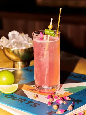a glass of pink drink with a lime on a table at Gold-Diggers in Los Angeles