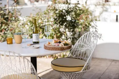 a table with a plate of food and a bottle of wine at Cuyama Buckhorn in New Cuyama