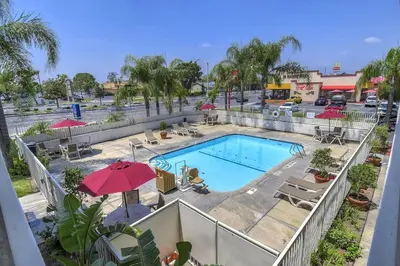 an overhead view of a pool with chairs and umbrellas at Motel 6-Fontana, CA in Fontana