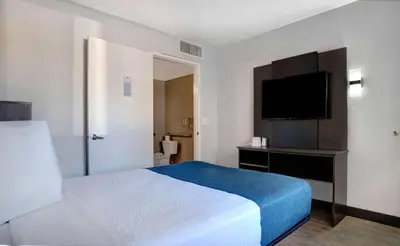 a hotel room with a bed and a flat screen tv at Motel 6-Bakersfield, CA - South in Bakersfield