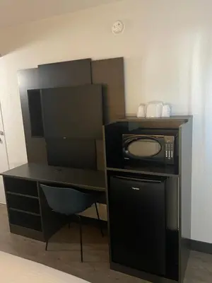 a room with a desk with a microwave and a computer at Motel 6-Bakersfield, CA - South in Bakersfield