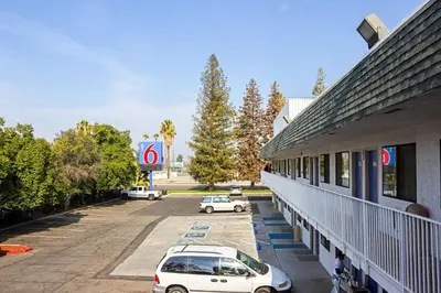 a group of cars parked in a parking lot next to a building at Motel 6-Porterville, CA in Porterville