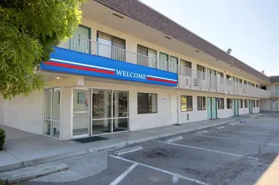 a building with a welcome sign in a parking lot at Motel 6-Porterville, CA in Porterville