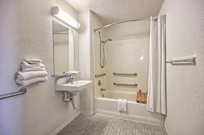 a white bathroom with a shower and a sink at Motel 6-Porterville, CA in Porterville