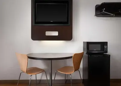 a table with two chairs and a television on a wall at Motel 6-Carpinteria, CA - Santa Barbara - North in Carpinteria